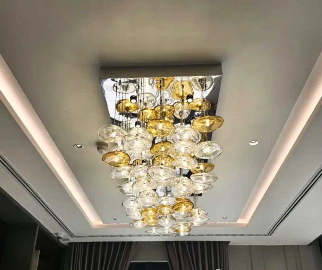 A sculptural disc chandelier glowing in a dark interior