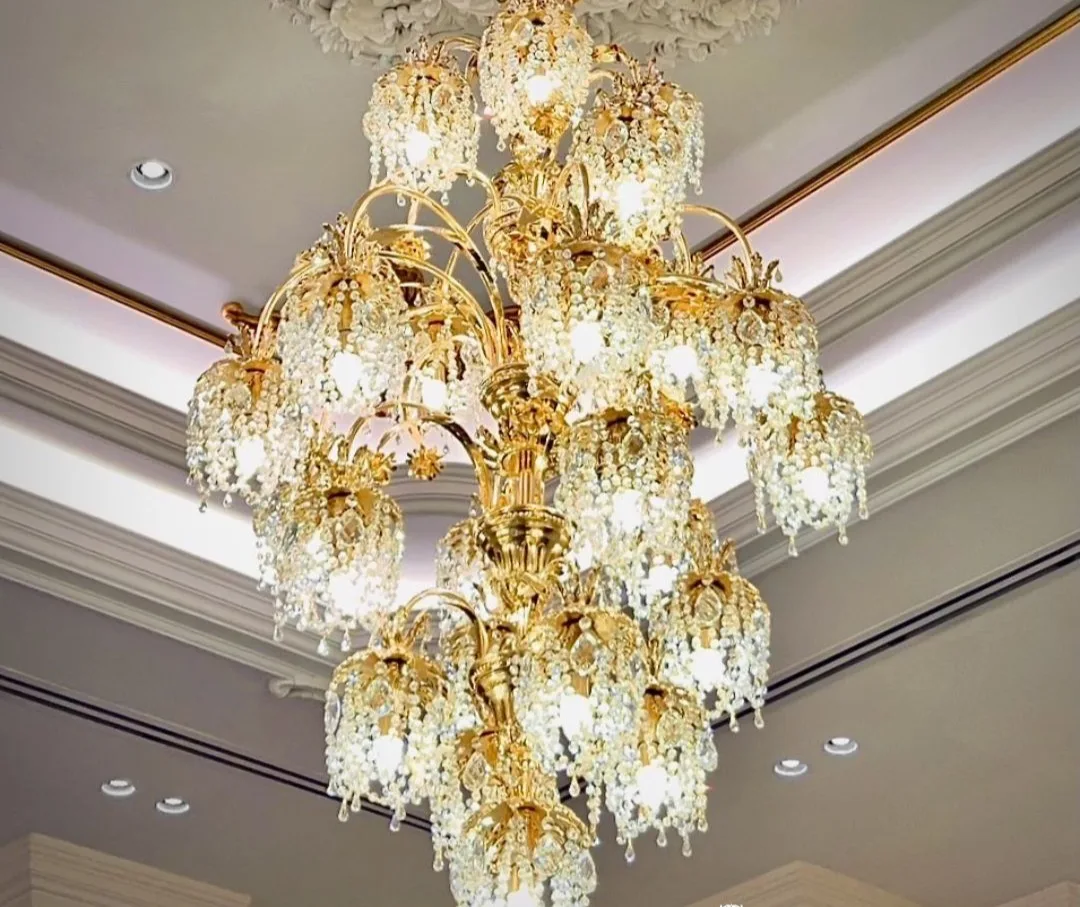 A crystal empire chandelier lit in a darkened room