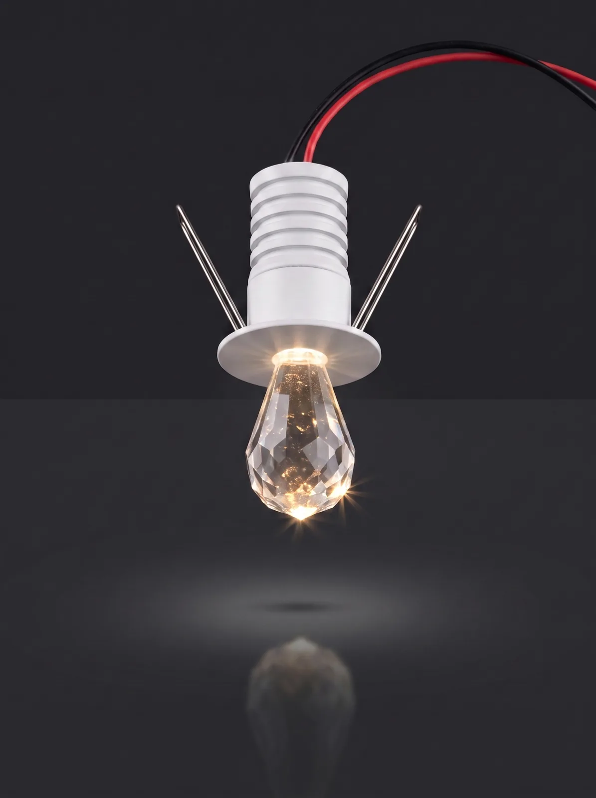 A crystal starlight spotlight with a faceted teardrop tip, lit warm