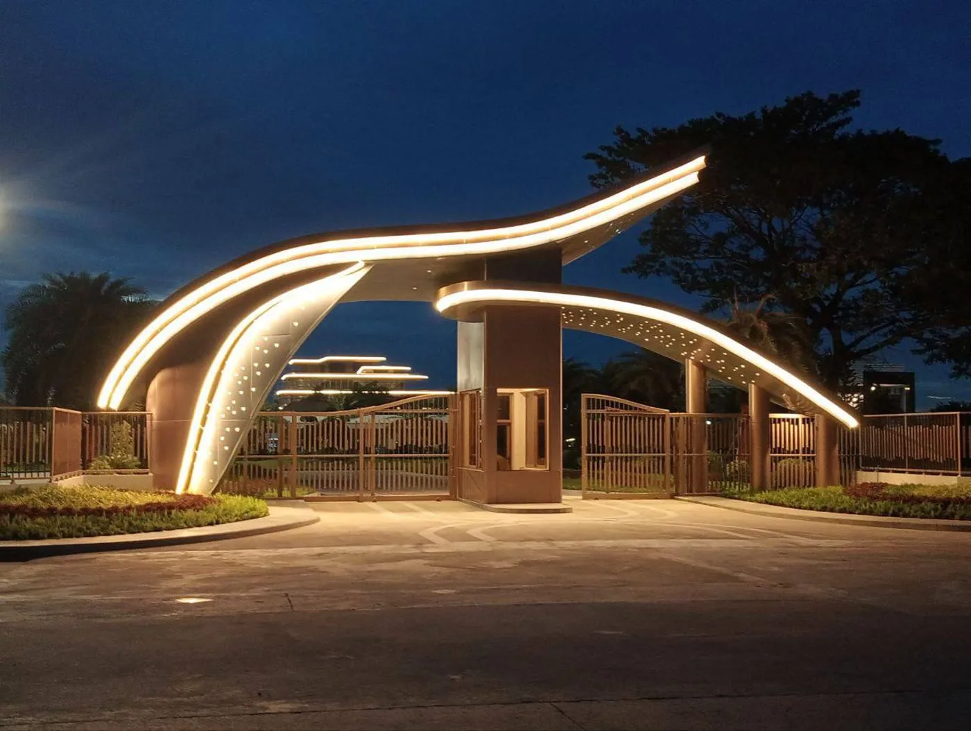 An illuminated sculptural entrance gateway at dusk