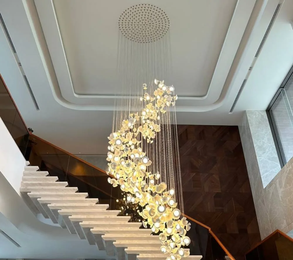A gold-leaf chandelier cascading down a villa staircase