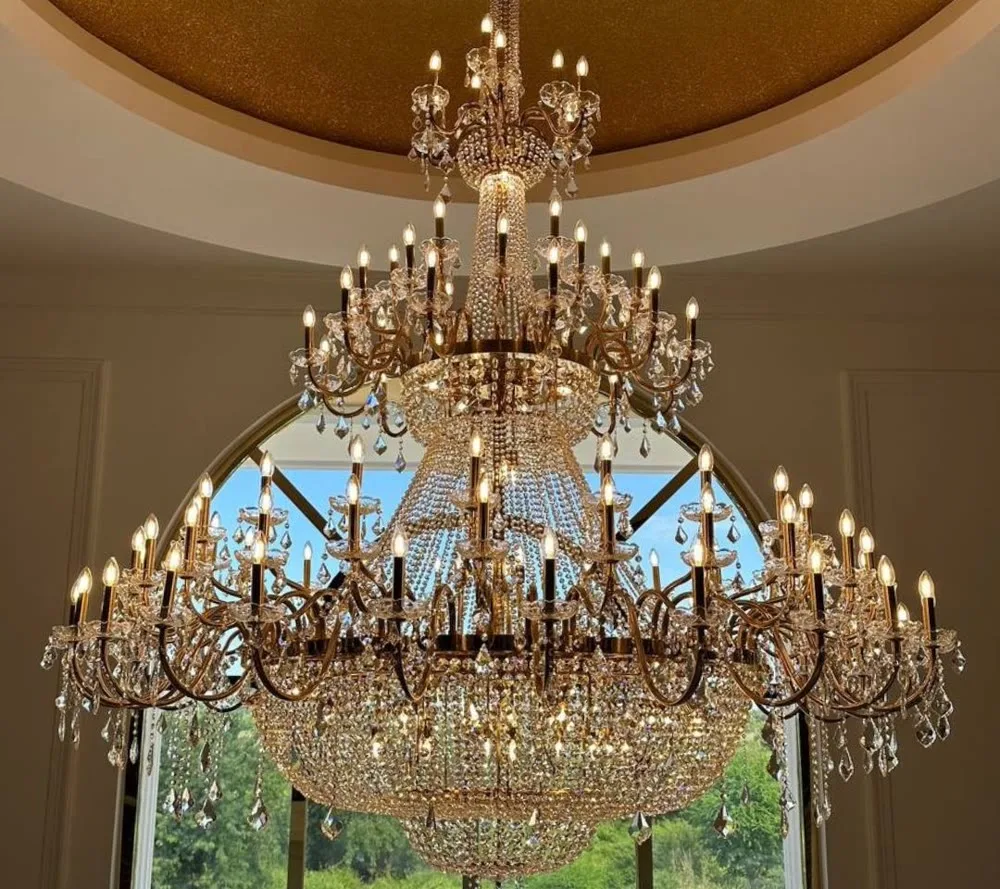A grand crystal empire chandelier before an arched window