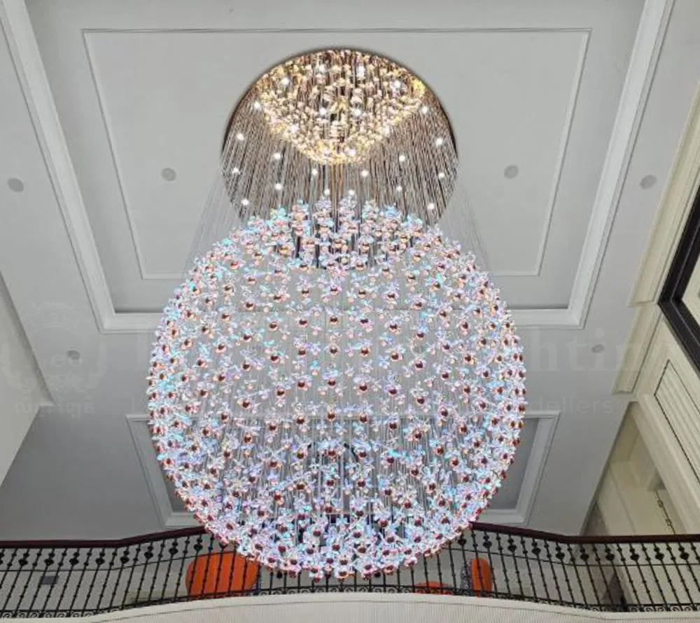 A large crystal orb chandelier over a stair balcony
